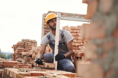 Dengeleyiciyi kullanarak. Yakışıklı Hintli adam şantiyede..