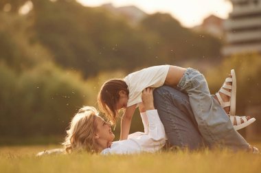 Yan görünüş, çocuğu elinde tutmak, uzanmak. Küçük kızıyla birlikte yaz tarlasındalar..