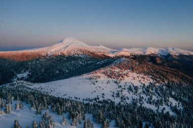 Görkemli Karpatya dağlarının kış havası. Gün batımlı arkaplan.