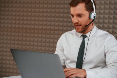 Laptop kullanıyorum. Resmi giyinmiş yakışıklı adam büroda..