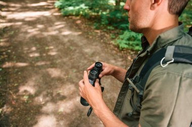 Yolu bulmaya çalışıyorum. Dürbünü tutuyorum. Yaz ormanında bir turist. Keşif ve eğlence kavramı.