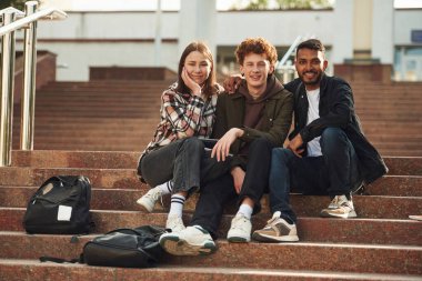Kameraya bakıyorum. Gündelik giysiler içindeki genç öğrenciler açık havada birlikteler..
