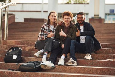 Kameraya bakıyorum. Gündelik giysiler içindeki genç öğrenciler açık havada birlikteler..