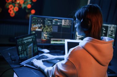 Ekranlar hakkında çok fazla bilgi. Genç profesyonel hacker bilgisayar başında..