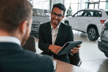 Grafik tablet kullanarak. Adam galeride müşteriye danışıyor..