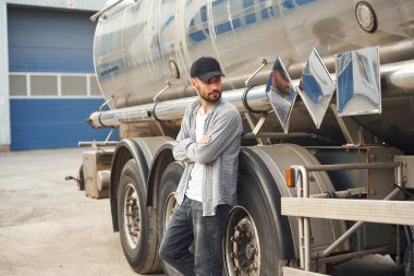 Araca yaslan. Gündelik giysiler içindeki genç kamyon şoförü..