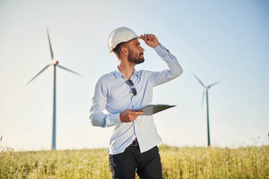 Yel değirmenleriyle sahada. Elinde not defteri olan servis mühendisi..