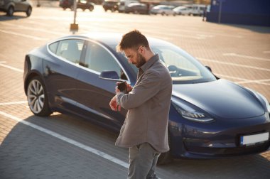 Saate bakıyorum. Adam dışarıda elektrikli arabasının yanında duruyor..