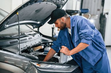 Yağı değiştirme süreci. Otomobil tamircisi garajda çalışıyor. Onarım servisi.