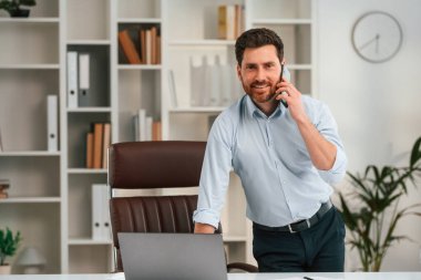 Telefonla. Resmi kıyafetli doktor dolapta çalışıyor..