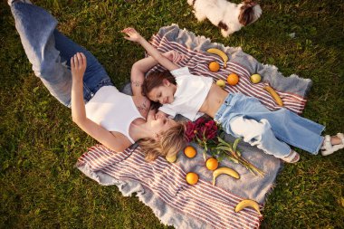 Portakallı ve muzlu battaniyenin üzerinde. Küçük kızıyla birlikte yaz tarlasındalar..