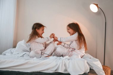 Yan görüş. Oynamak, eğlenmek. İki küçük kız yurt odasında birlikteler..