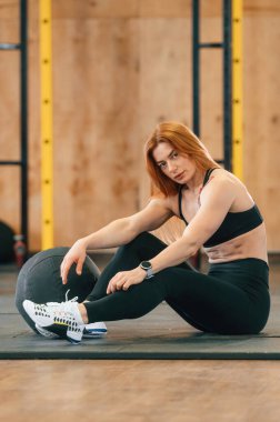 Oturuyor, rahatlıyor. Güzel, güçlü kadın spor salonunda..