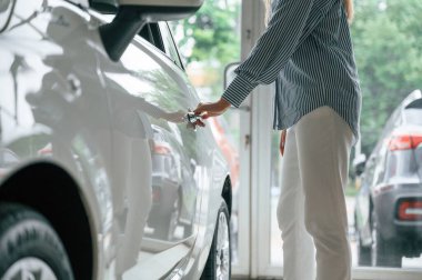 Kapıyı açıyorum. Elektrikli arabalı bir kadının yakın görüntüsü.