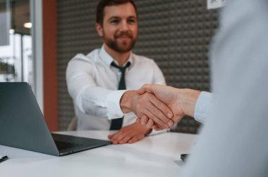 El sıkışmak, tanıştığımıza memnun oldum. Ofis çalışanları masanın yanında..