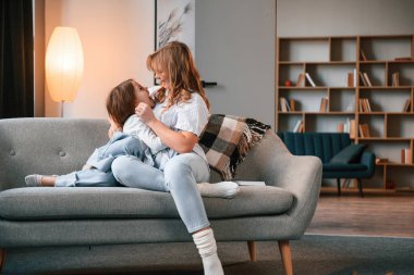 Eğleniyoruz, kucaklaşıyoruz. Anne ve küçük kızı evdeki odada birlikteler..