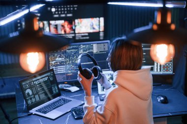 Yapay ışıklandırma. Genç profesyonel bilgisayar korsanı bilgisayar başında ve ekranlar hakkında çok fazla bilgiye sahip..