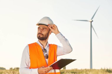 Not defteriyle. Servis mühendisi yel değirmenleriyle sahada..