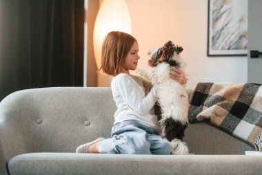 Kanepede oturuyordum. Küçük kız sevimli bir köpekle evde..