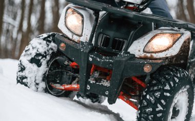 Kar, ağaçlar, macera. İnsan kış ormanlarında ATV 'ye biniyor..