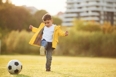Oğlan futbol topuyla yaz sahasında..