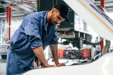 Arabayı tamir ederek işe yarıyor. Kaput açıldı. Tamirci garajda. Onarım servisi.