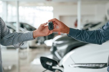 Resmi elbiseli adam elektrikli arabalı kadın müşteriyle birlikte..