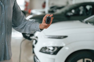 Anahtarlar elinde. Elektrikli arabalı adamın yakın görüntüsü..