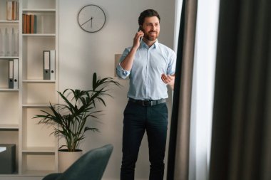 Telefonla. Resmi kıyafetli doktor dolapta çalışıyor..