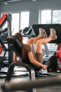 Bacaklar için egzersiz yapıyorum. Spor vücut yapısı olan güzel bir kadın spor salonunda..