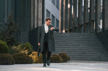 Köknar ağaçlarının yanında yürüyorum. Resmi giyinmiş yakışıklı adam dışarıda..