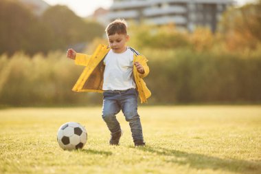 Oğlan futbol topuyla yaz sahasında..