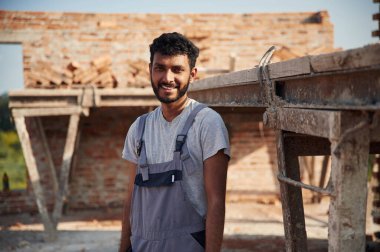 Şantiyede neşeli ve yakışıklı Hintli bir adam var..