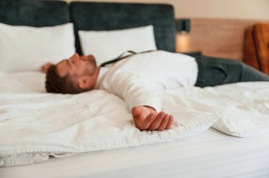 Yorgunum, yatağa uzanıyorum. İş adamı içeride, otel odasında..