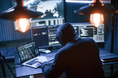 Dikiz aynası. Erkek profesyonel hacker bilgisayar başında oturuyor, virüs kavramı..