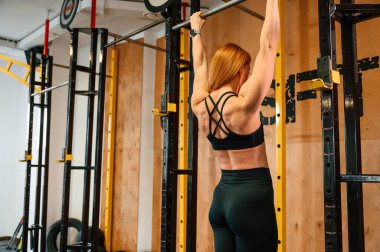 Barfiks egzersizi. Güzel, güçlü kadın spor salonunda..