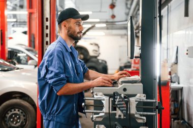Bilgisayar terminali hazır. Otomobil tamircisi garajda çalışıyor. Onarım servisi.