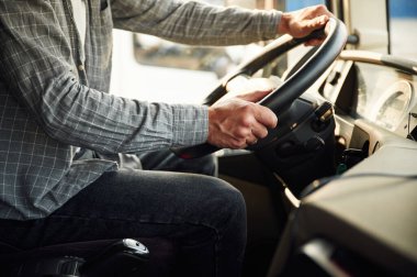 Manzarayı kapat, içeride otur. Gündelik giysiler içindeki genç kamyon şoförü..