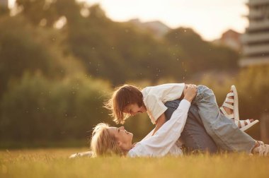 Yan görünüş, çocuğu elinde tutmak, uzanmak. Küçük kızıyla birlikte yaz tarlasındalar..
