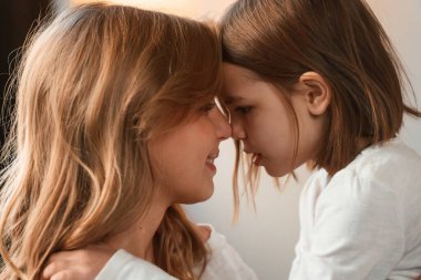 Yan görüş, birbirimizi kucaklamak. Anne ve küçük kızı evdeki odada birlikteler..