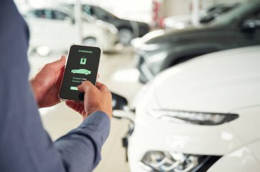 Şarj işlemi bilgisi. Elektrikli arabalı adamın yakın görüntüsü..