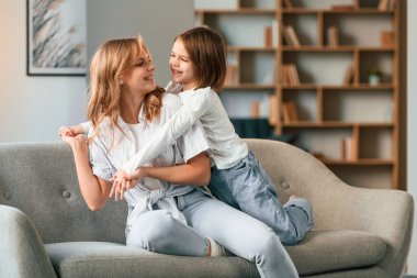 Eğleniyoruz, kucaklaşıyoruz. Anne ve küçük kızı evdeki odada birlikteler..