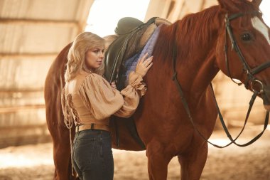 Hayvanlara bakıyorum. Güzel genç bir kadın atıyla içeride..