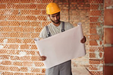 Belgeyi tutuyorum. Yakışıklı Hintli adam şantiyede..