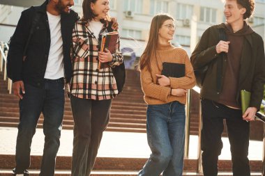 Ön manzara. Gündelik giysiler içinde dört genç dışarıda beraberler..
