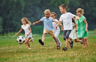 Futbol, birlikte oynamak. Çocuklar gündüz vakti sahada eğleniyorlar..