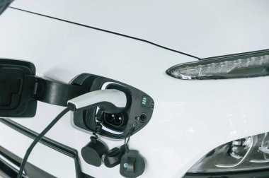 Şarj olan beyaz renkli elektrikli arabanın yakın görüntüsü.