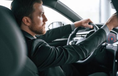 Arabayı sürüyorum. Resmi iş elbiseli adam modern otomobilde oturuyor..