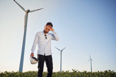 Yorgun, sıcak hava. Servis mühendisi yel değirmenleriyle sahada..