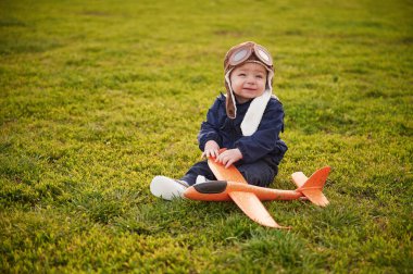 Küçük çocuk oyuncak uçağıyla yaz sahasında..